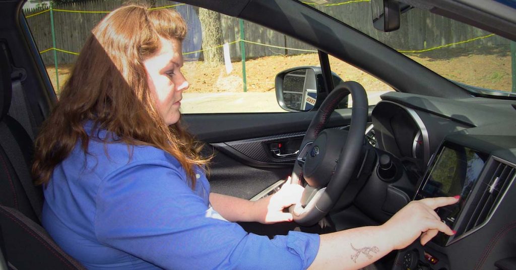 Amber picks a song with the apps on the Subaru Impreza Sport