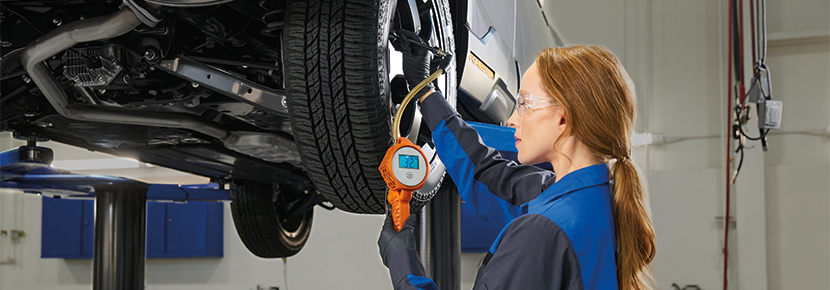 A Subaru technician checking tire pressure. | Goldstein Subaru in Colonie NY