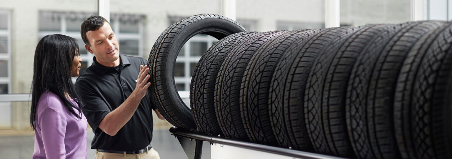 Subaru service representative showing customer a tire. | Goldstein Subaru in Colonie NY
