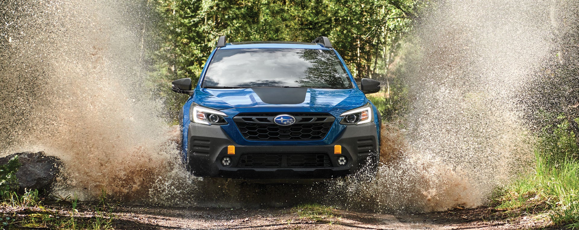 A 2023 Outback Wilderness driving on a muddy trail. | Goldstein Subaru in Colonie NY